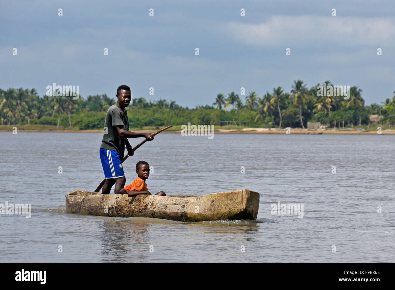 Fon man and son in dugout canoe on the Mono River, Benin Stock Photo