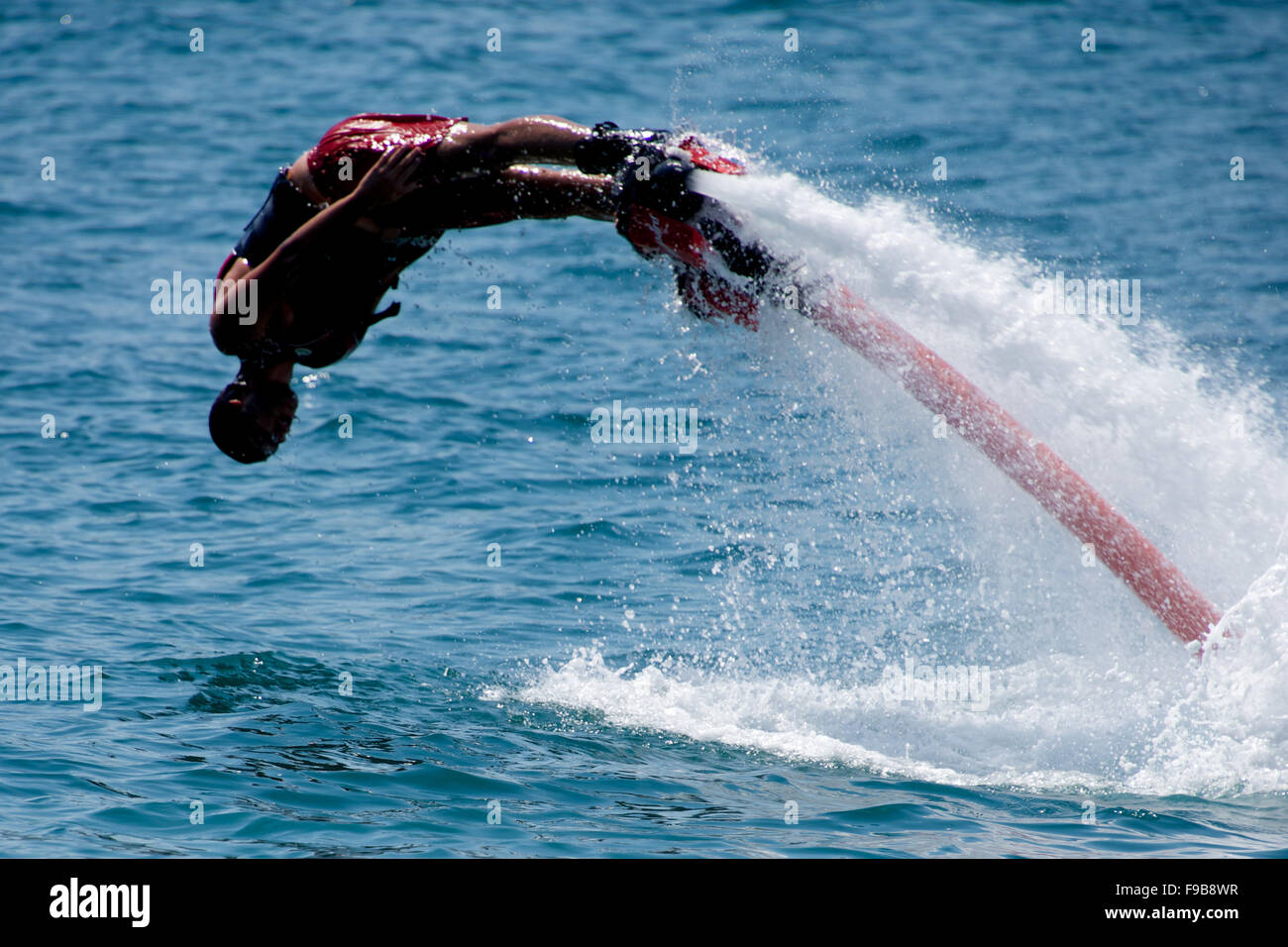 Flyboarder in red shorts diving into sea Stock Photo Alamy