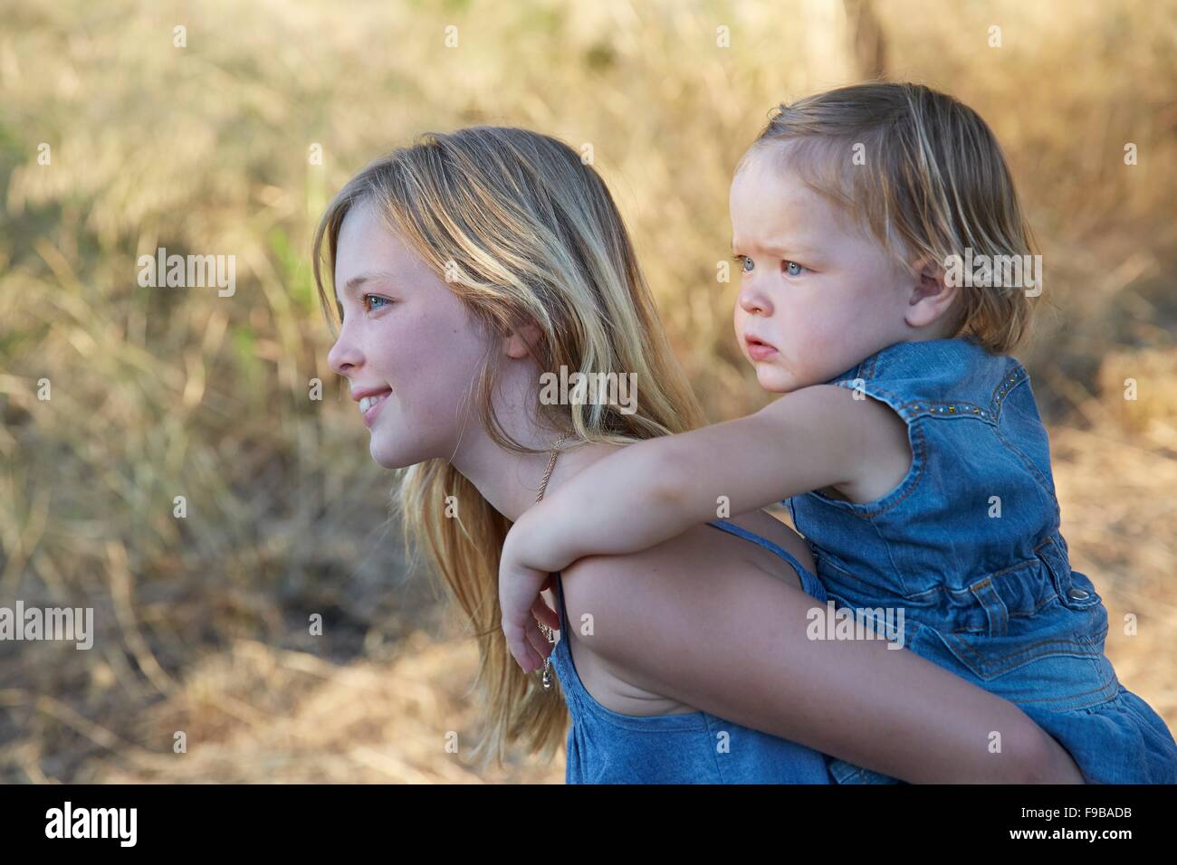 MODEL RELEASED. Girl carrying her sister on her back. Stock Photo