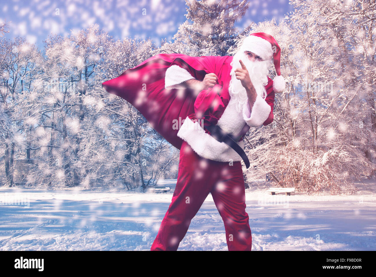 Santa Claus walking in the snow pointing his finger Stock Photo