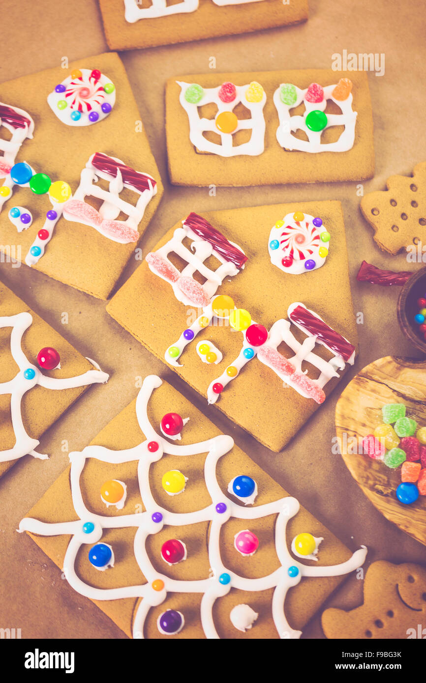 Decorating gingerbread house with royal icing and colorful candies ...