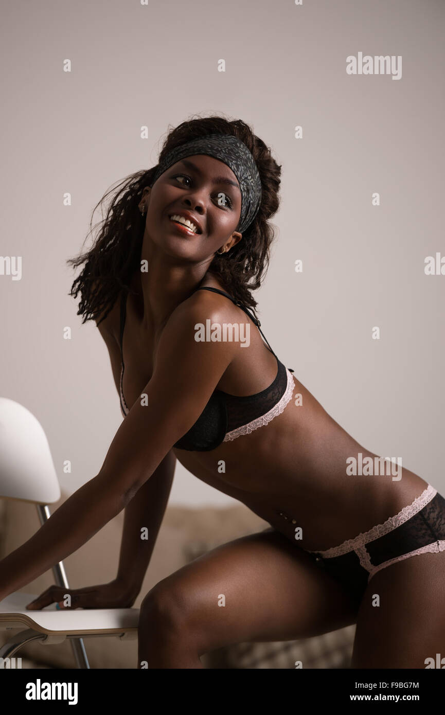 Beautiful african lady posing with chair at home wearing only sexy lingerie  Stock Photo - Alamy