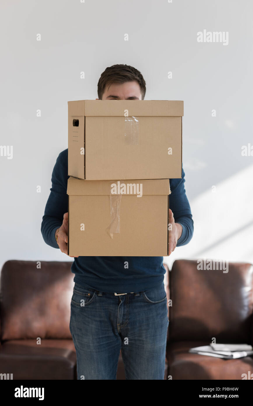 Man holding cardboard boxes at home - moving in new home and mortgage concept Stock Photo