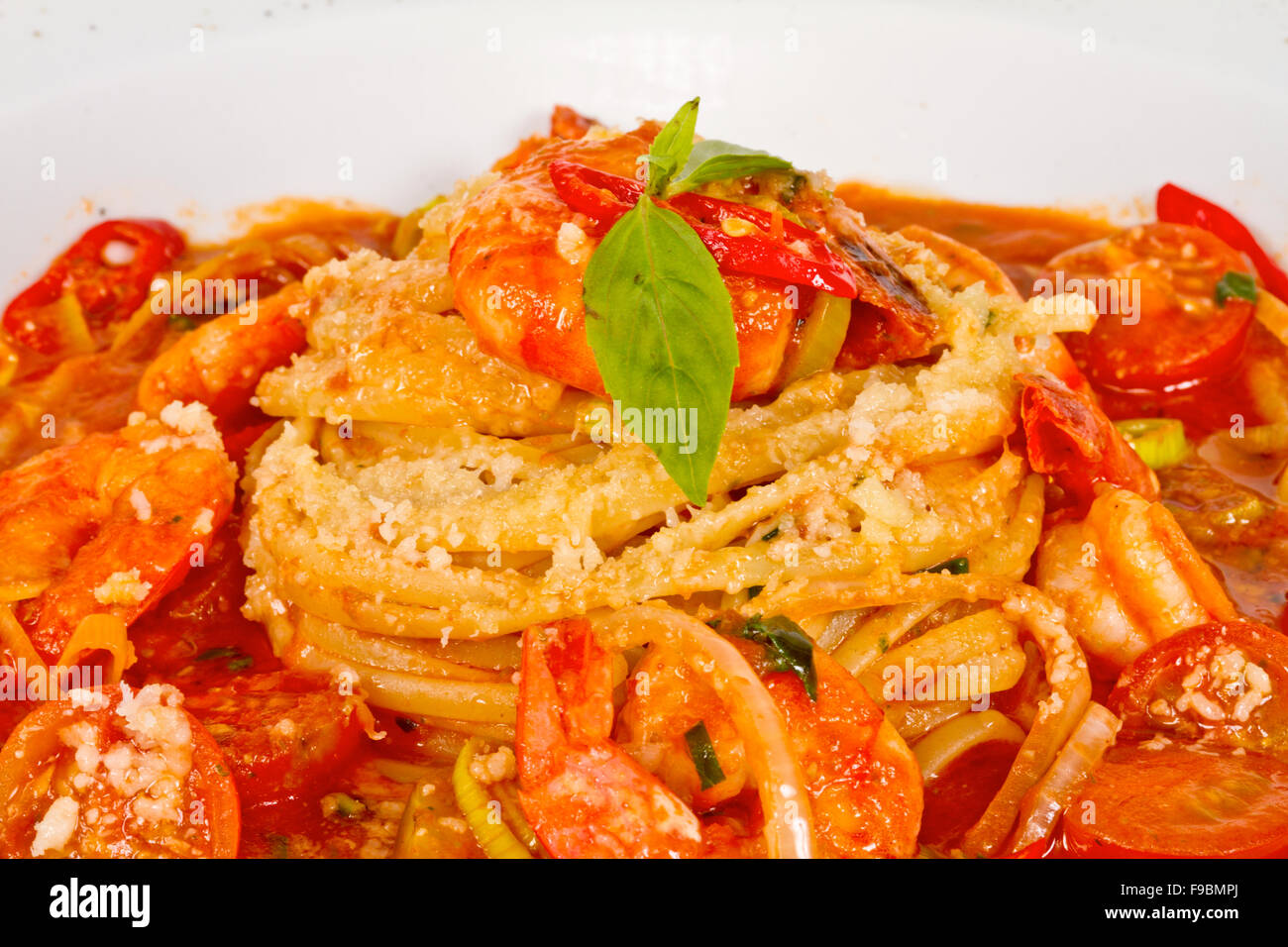A plate of linguini with sauteed shrimp, tomato, chili and olive oil ...