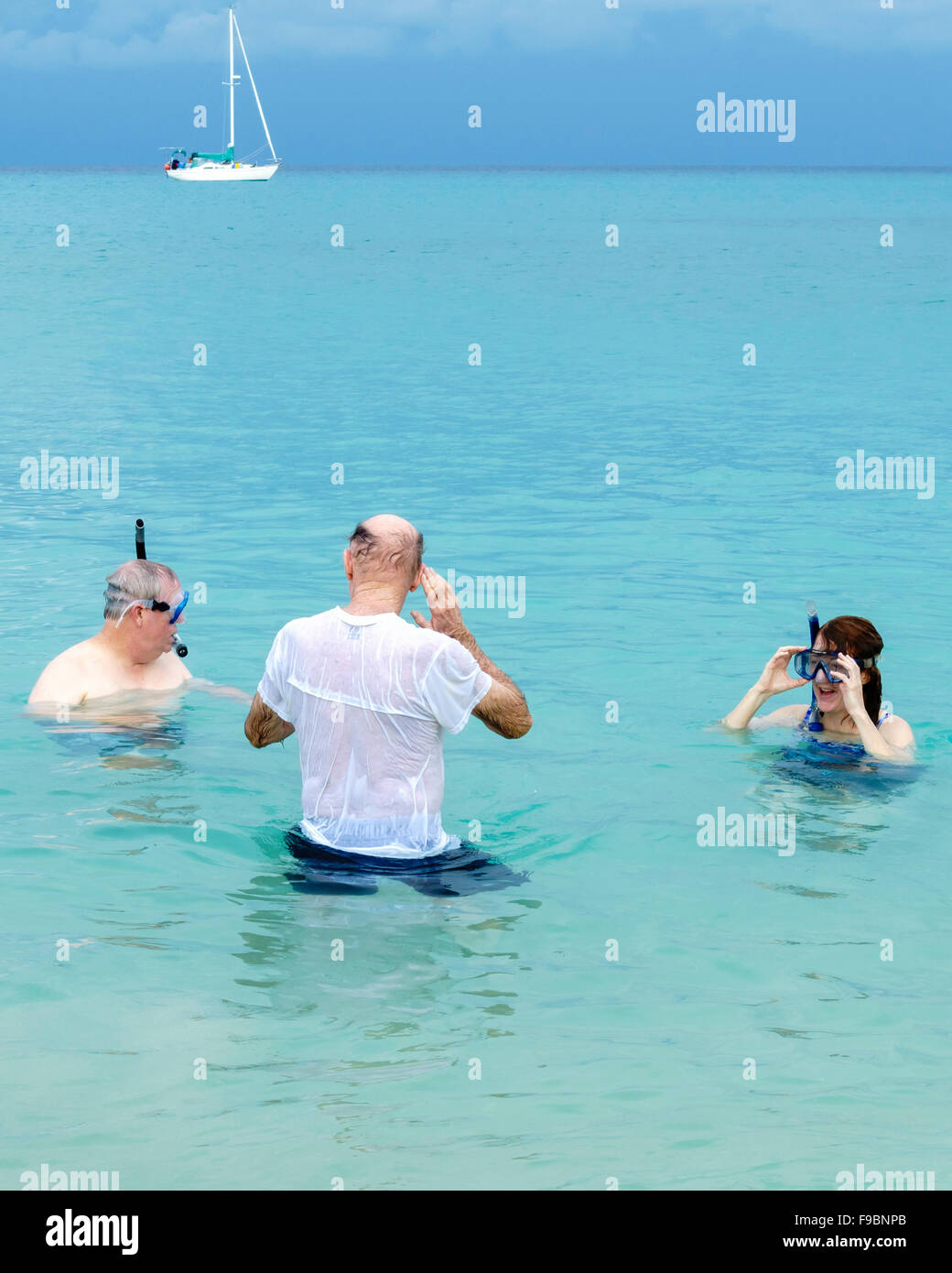 Three Caucasian family members ages 50-77 enjoy snorkeling in the Caribbean off St. Croix, U.S. Virgin Islands. Stock Photo