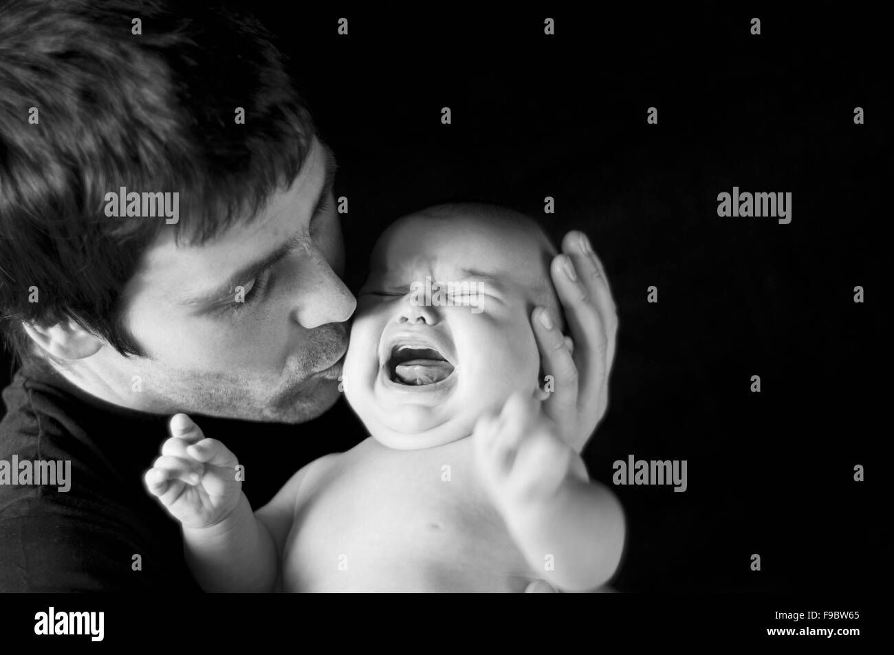 Young father with his crying baby in studio Stock Photo
