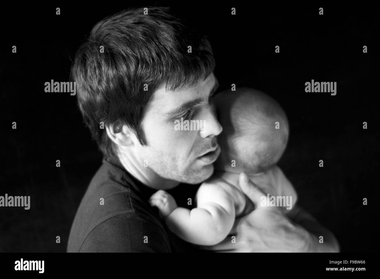 Young father with his crying baby in studio Stock Photo