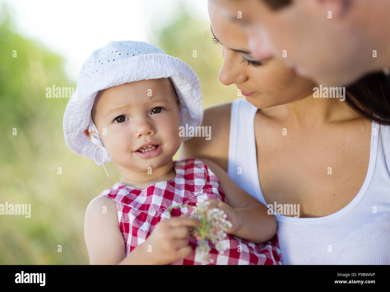 Happy young family spending time together in green nature. Stock Photo