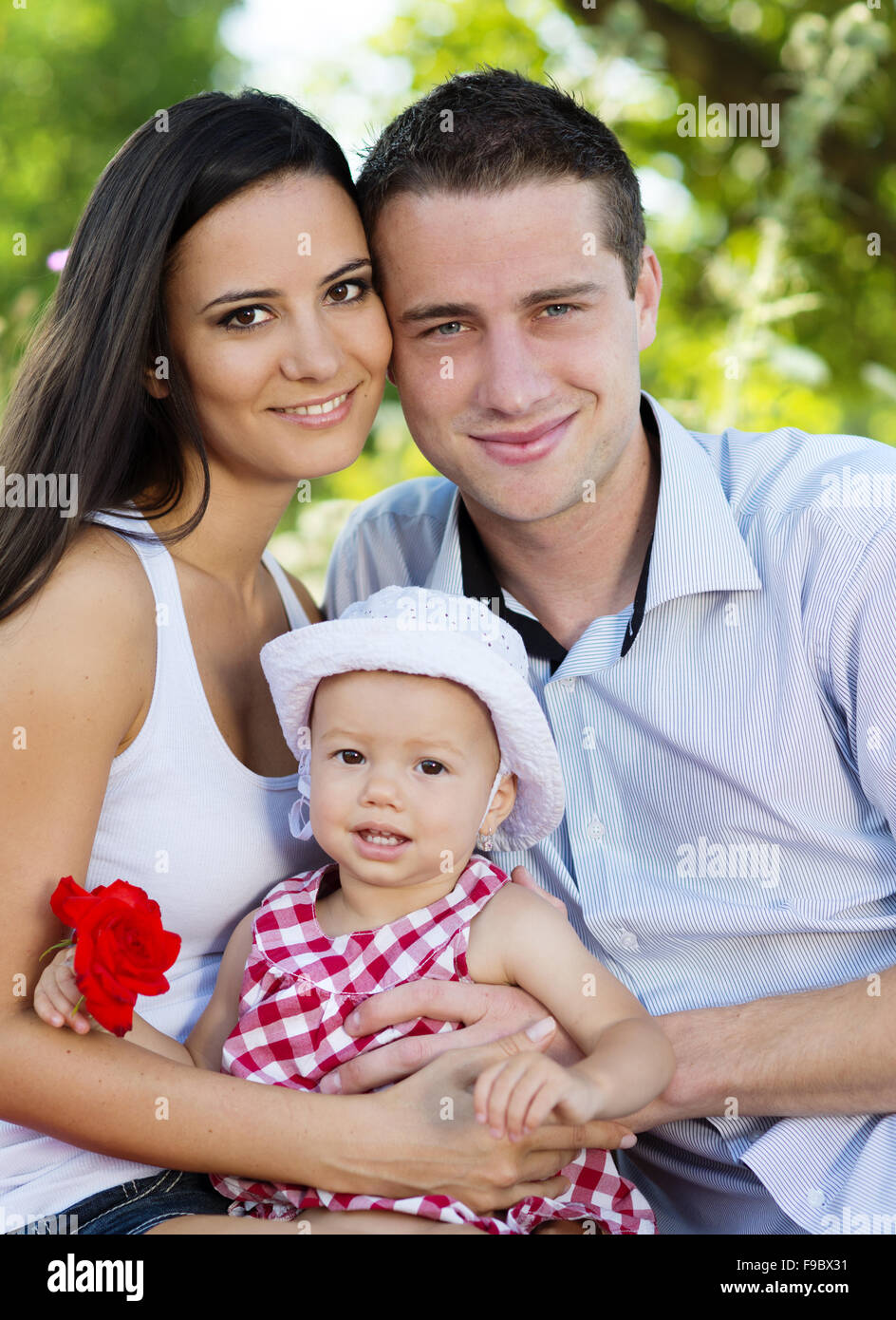 Happy young family spending time together in green nature. Stock Photo