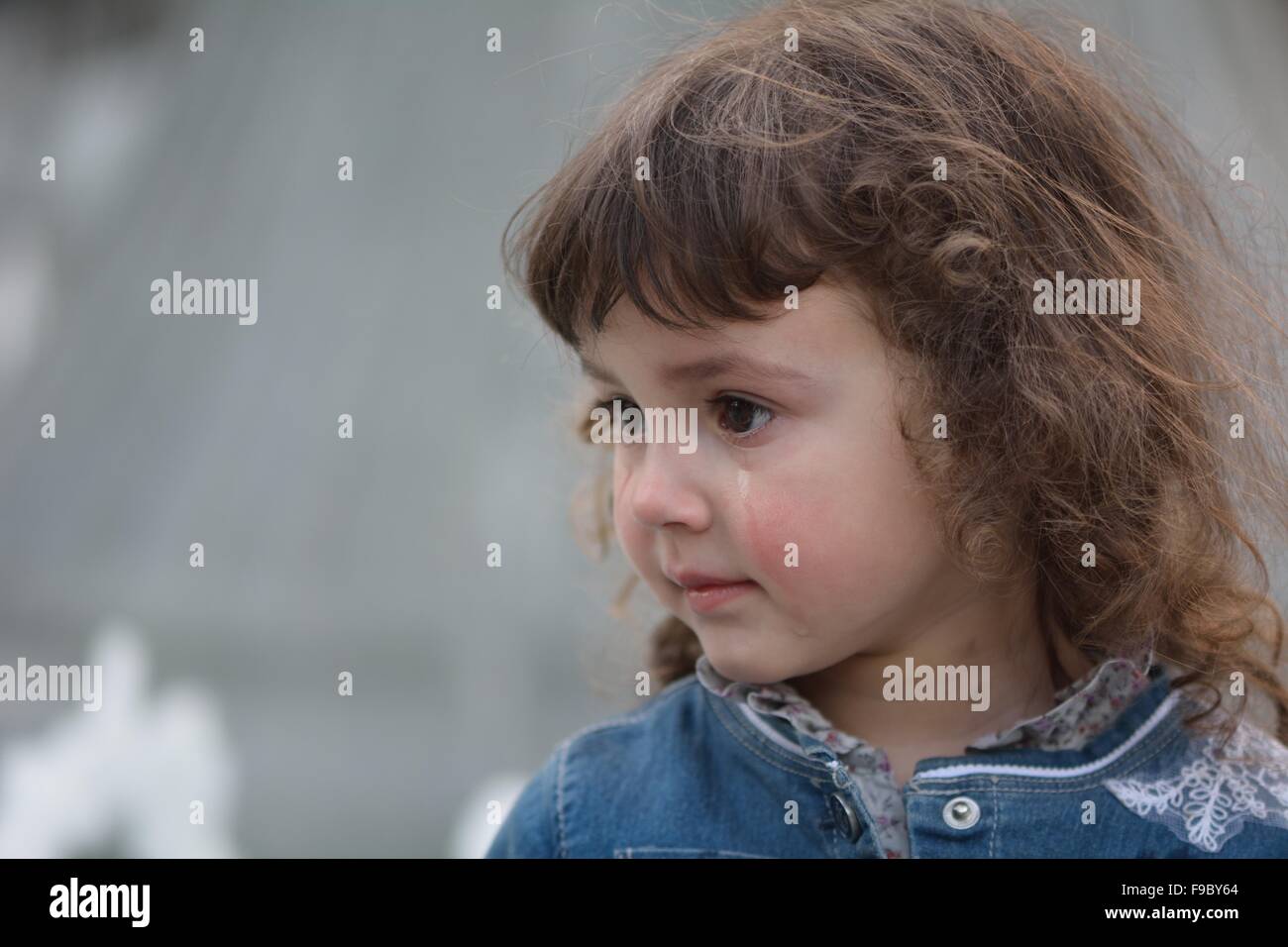 Young girl with tear running down cheek Stock Photo