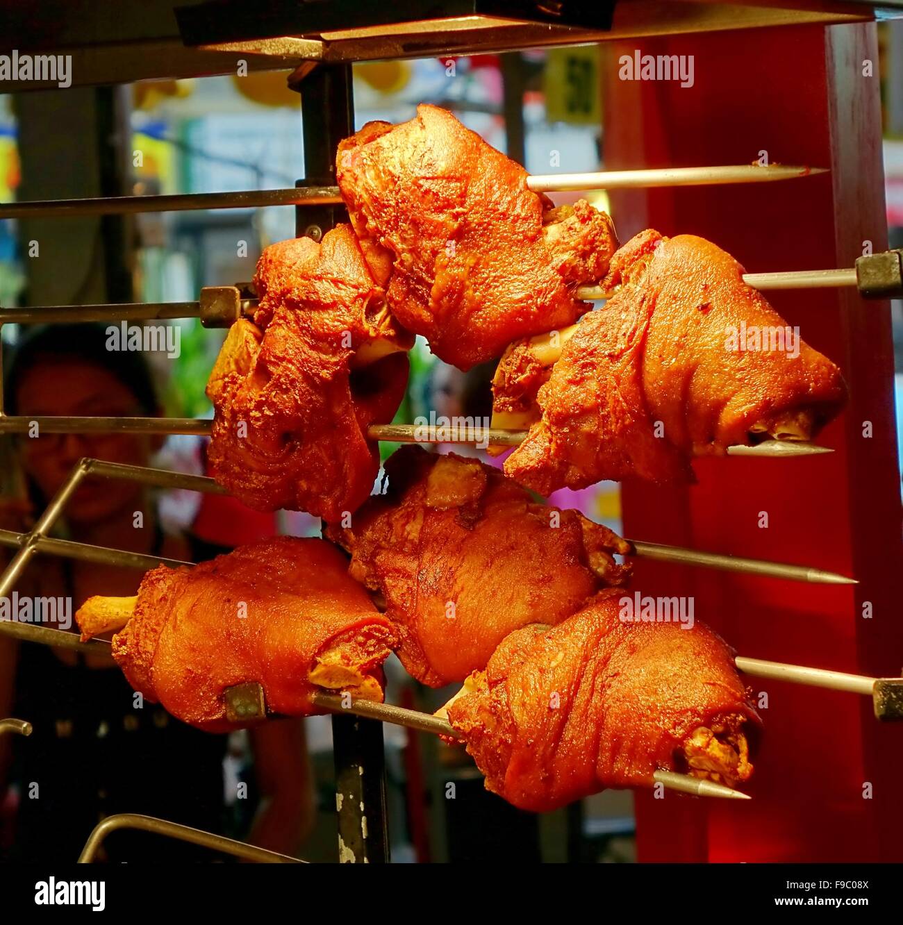 An outdoor vendor sells grilled pork knuckles or ham hock Stock Photo