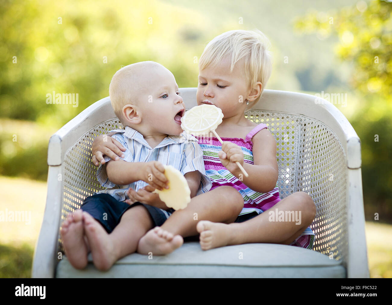 Two happy kids eating lolly in the park Stock Photo