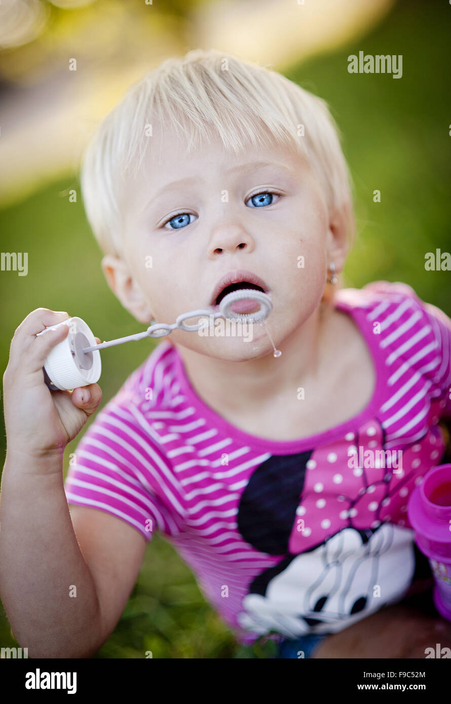 Happy little girl is playing in the green sunny park Stock Photo - Alamy