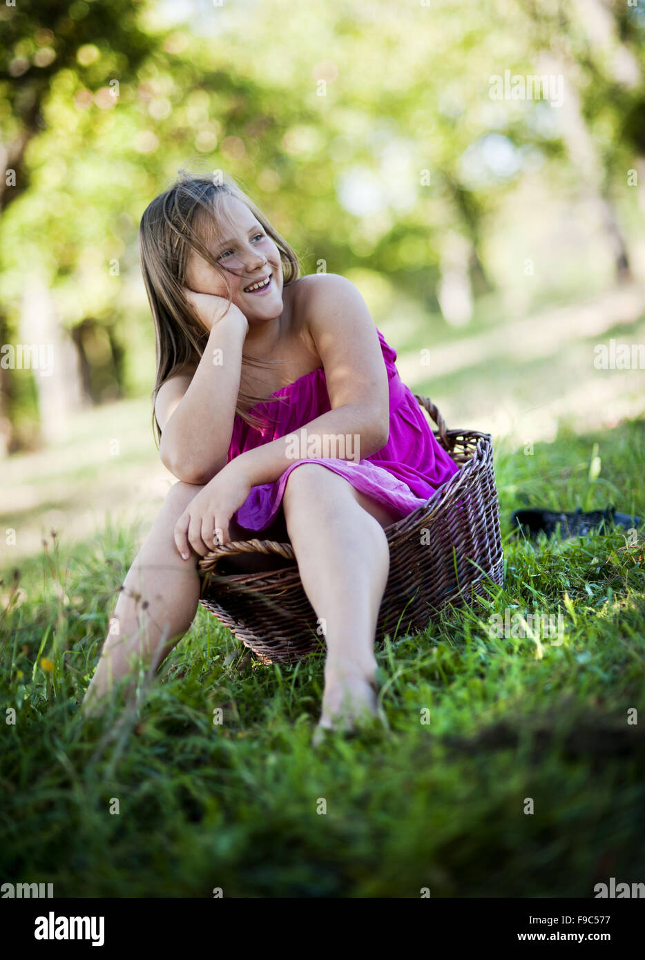Happy little girl is playing in the green sunny park Stock Photo - Alamy