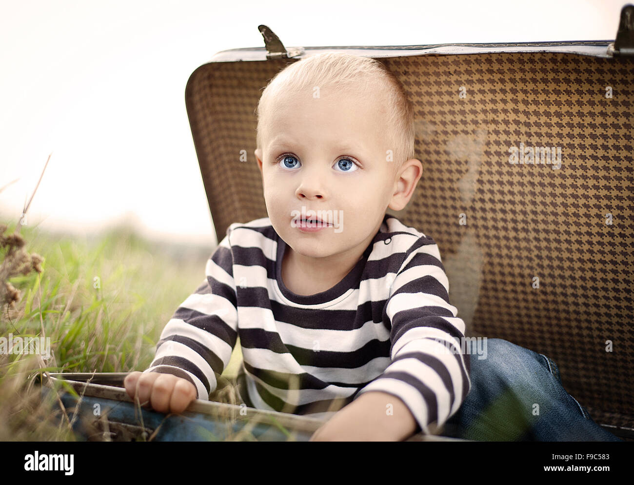 Cute little boy playing in the old suitcase Stock Photo Alamy