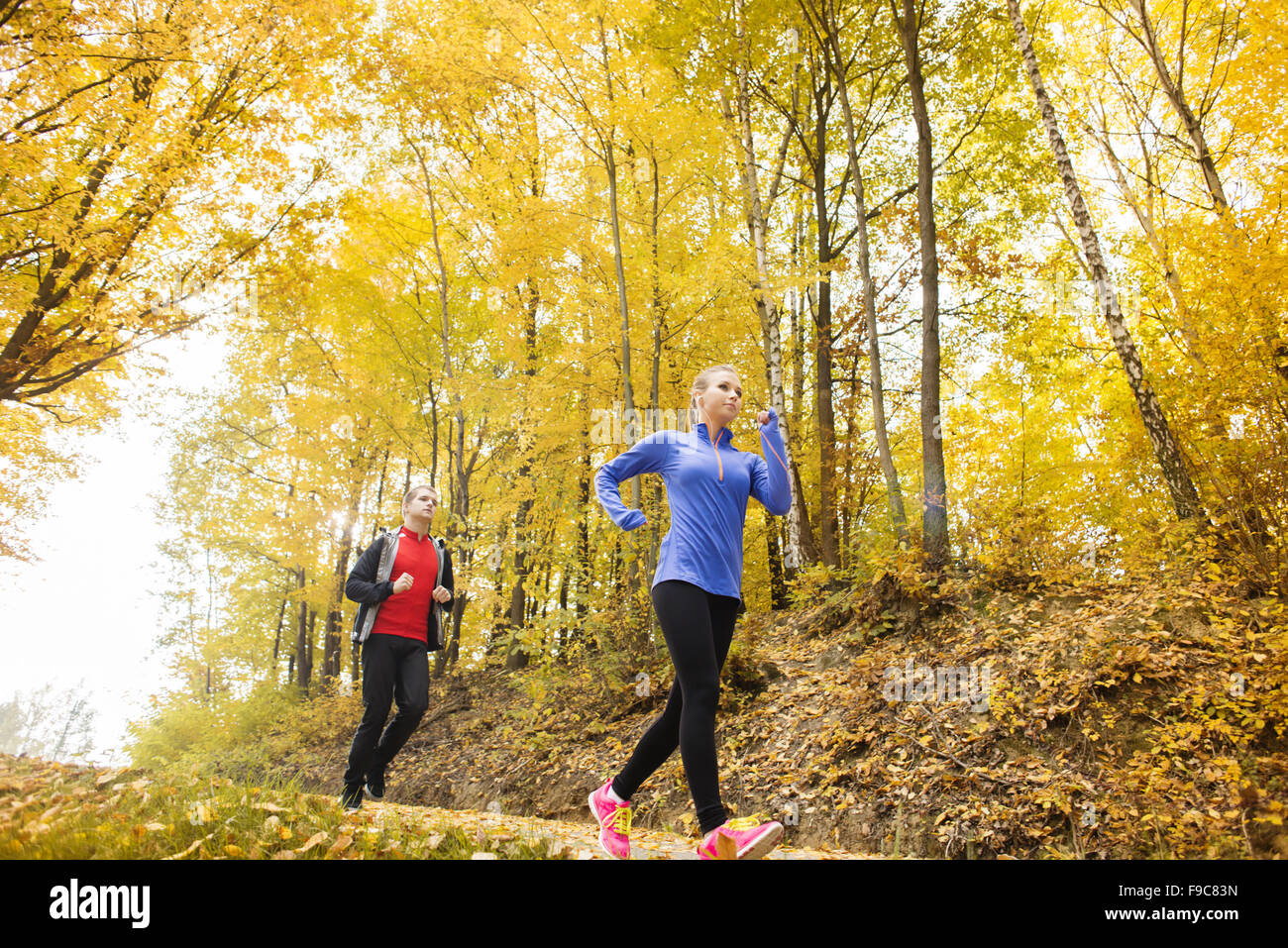 Young running couple jogging in autumn nature Stock Photo - Alamy