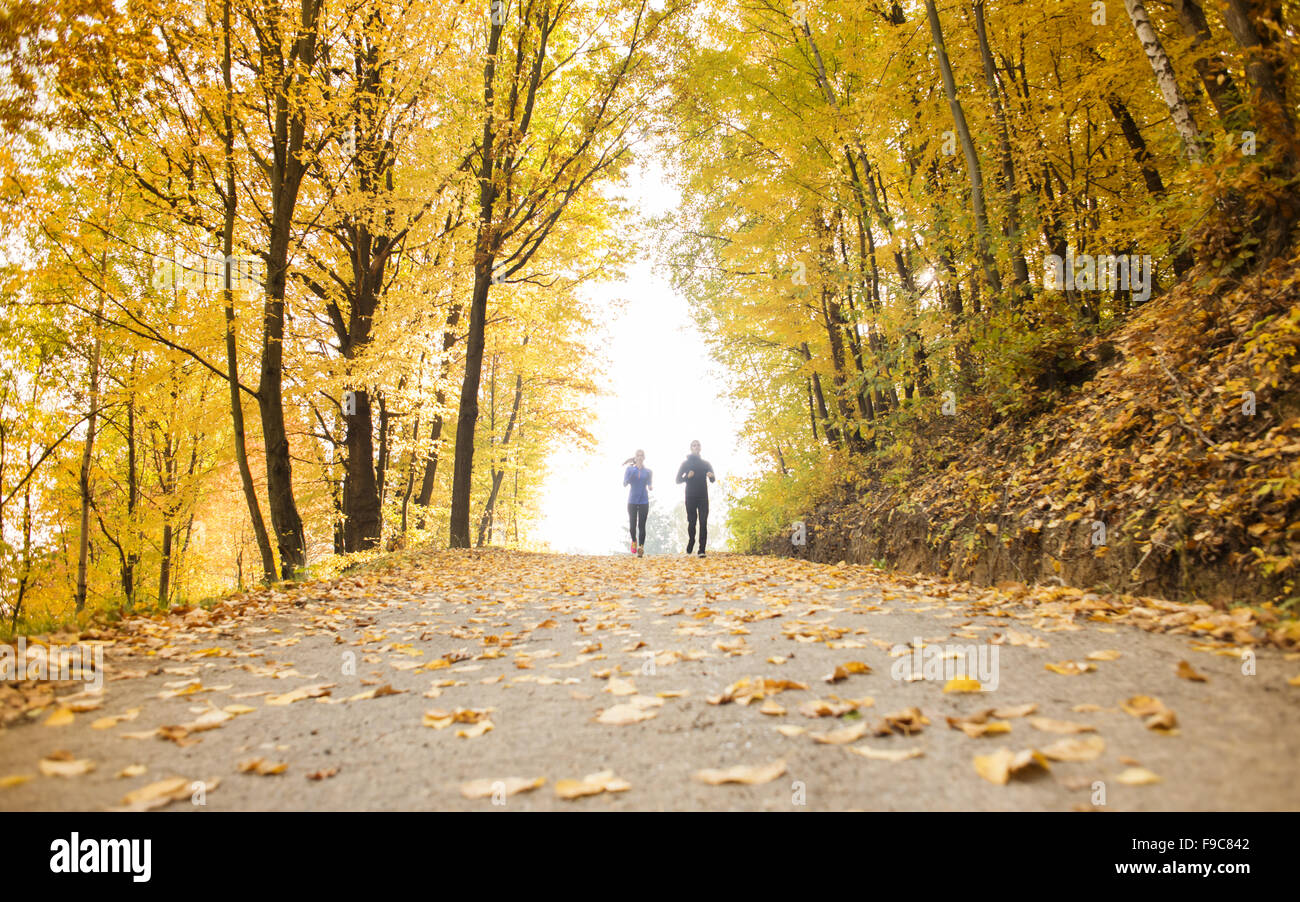 Young running couple jogging in autumn nature Stock Photo - Alamy