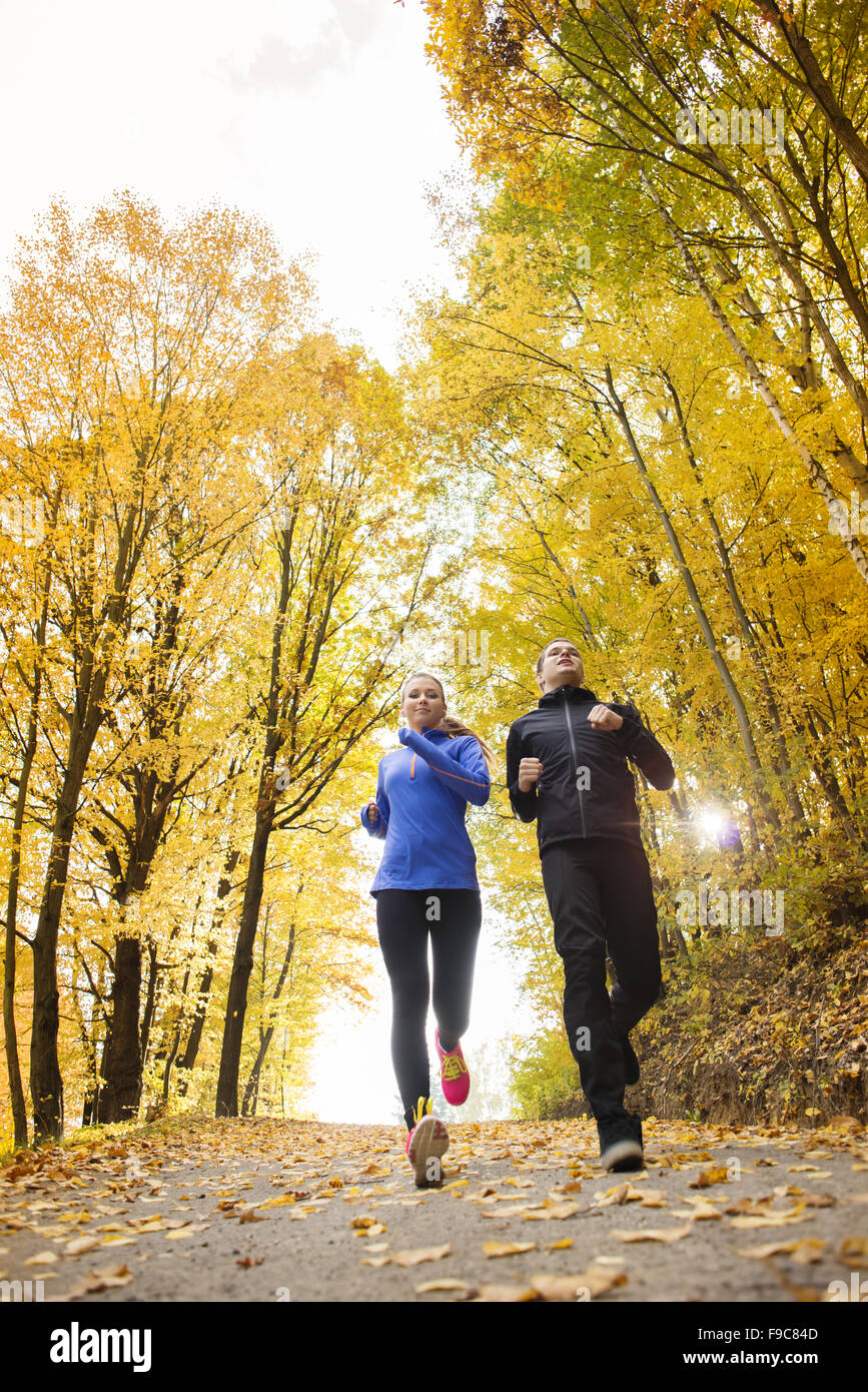 Young running couple jogging in autumn nature Stock Photo - Alamy