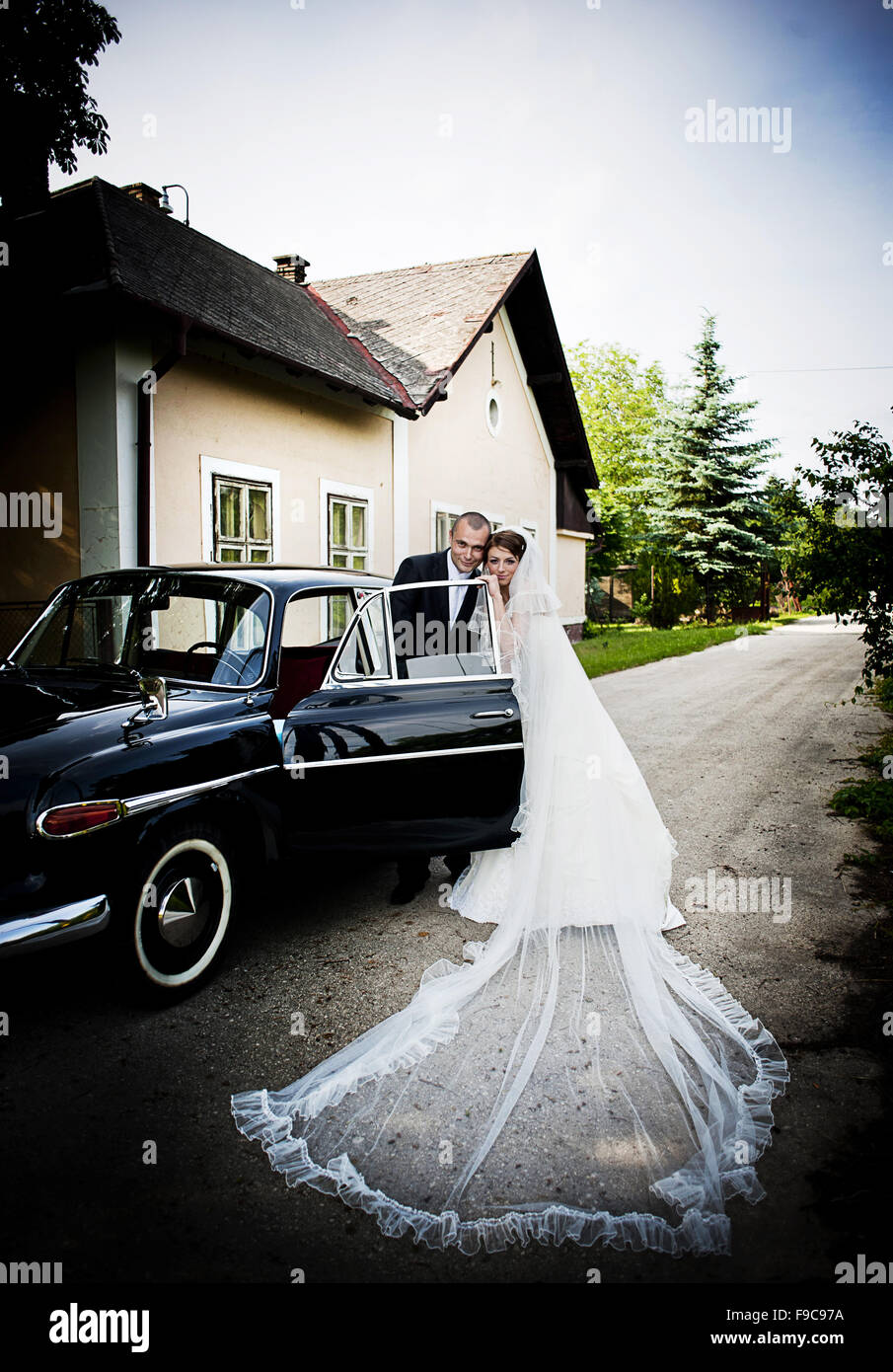 Happy bride and groom in a black car on wedding day Stock Photo - Alamy