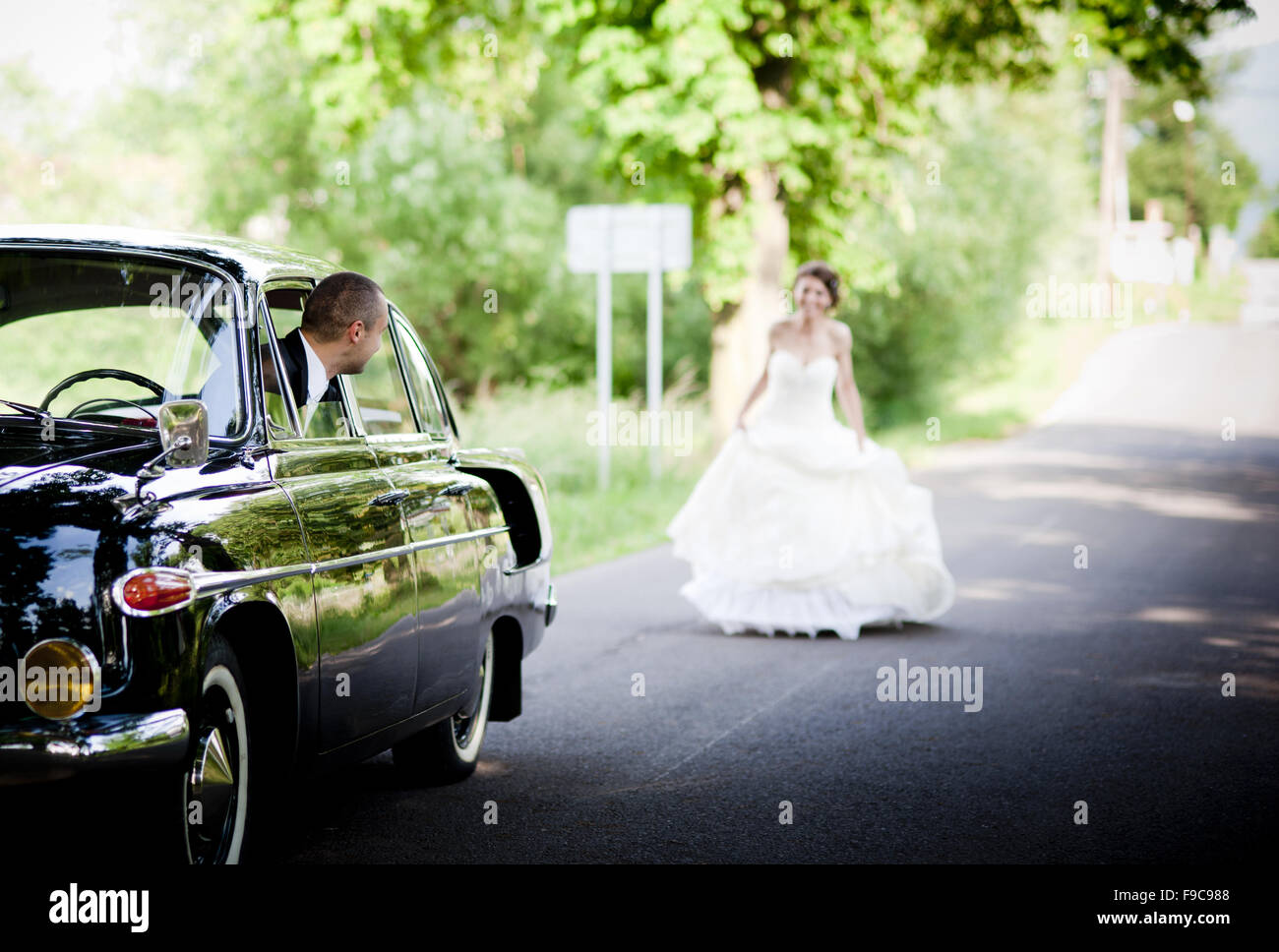 Happy bride and groom in a black car on wedding day Stock Photo - Alamy