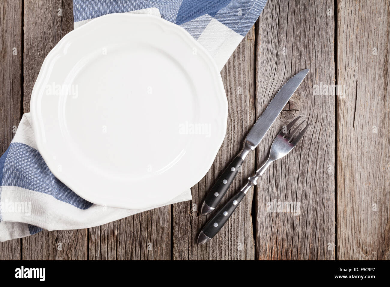 Empty plate and silverware on wooden table. Top view Stock Photo - Alamy