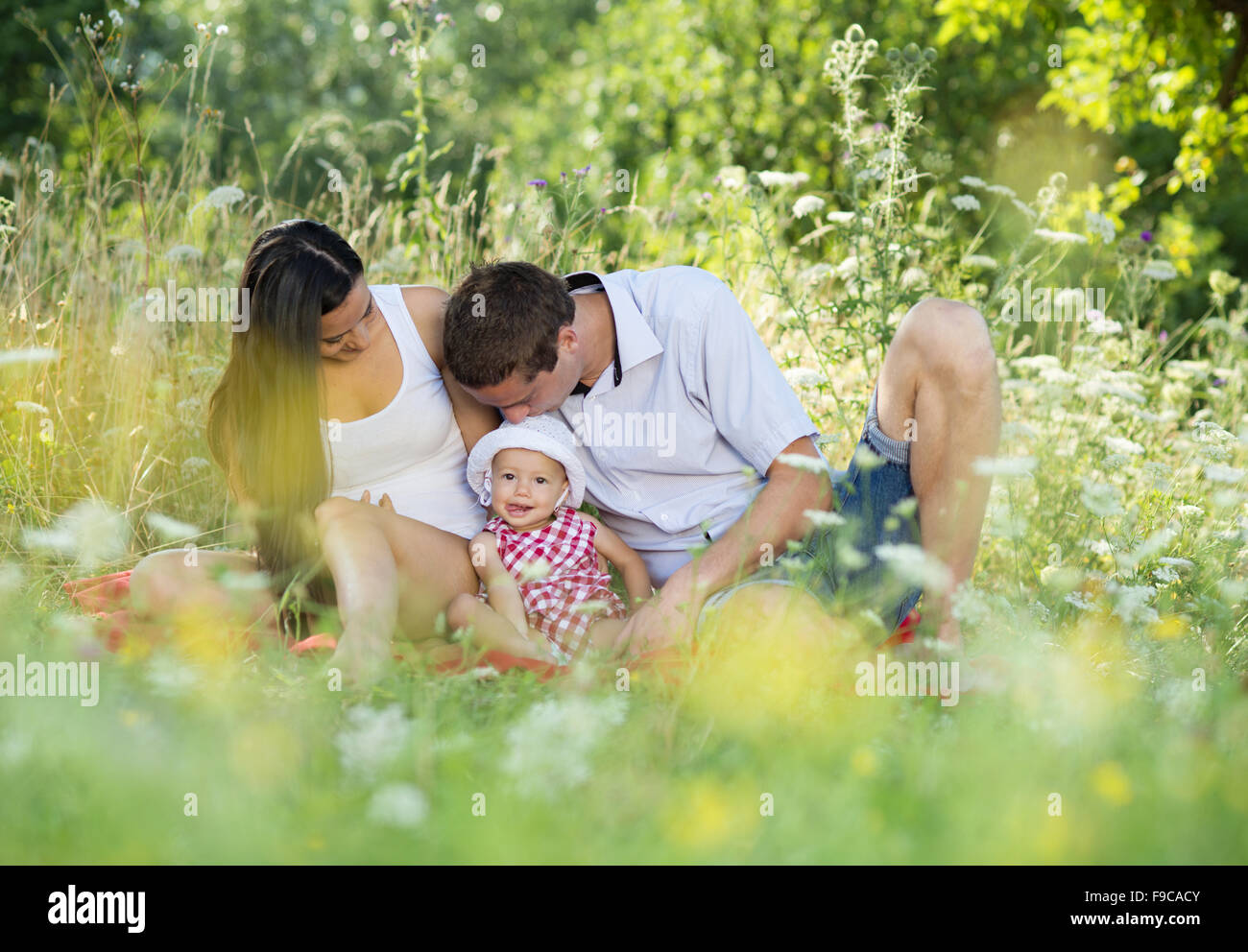 Happy young family spending time together in green nature. Stock Photo