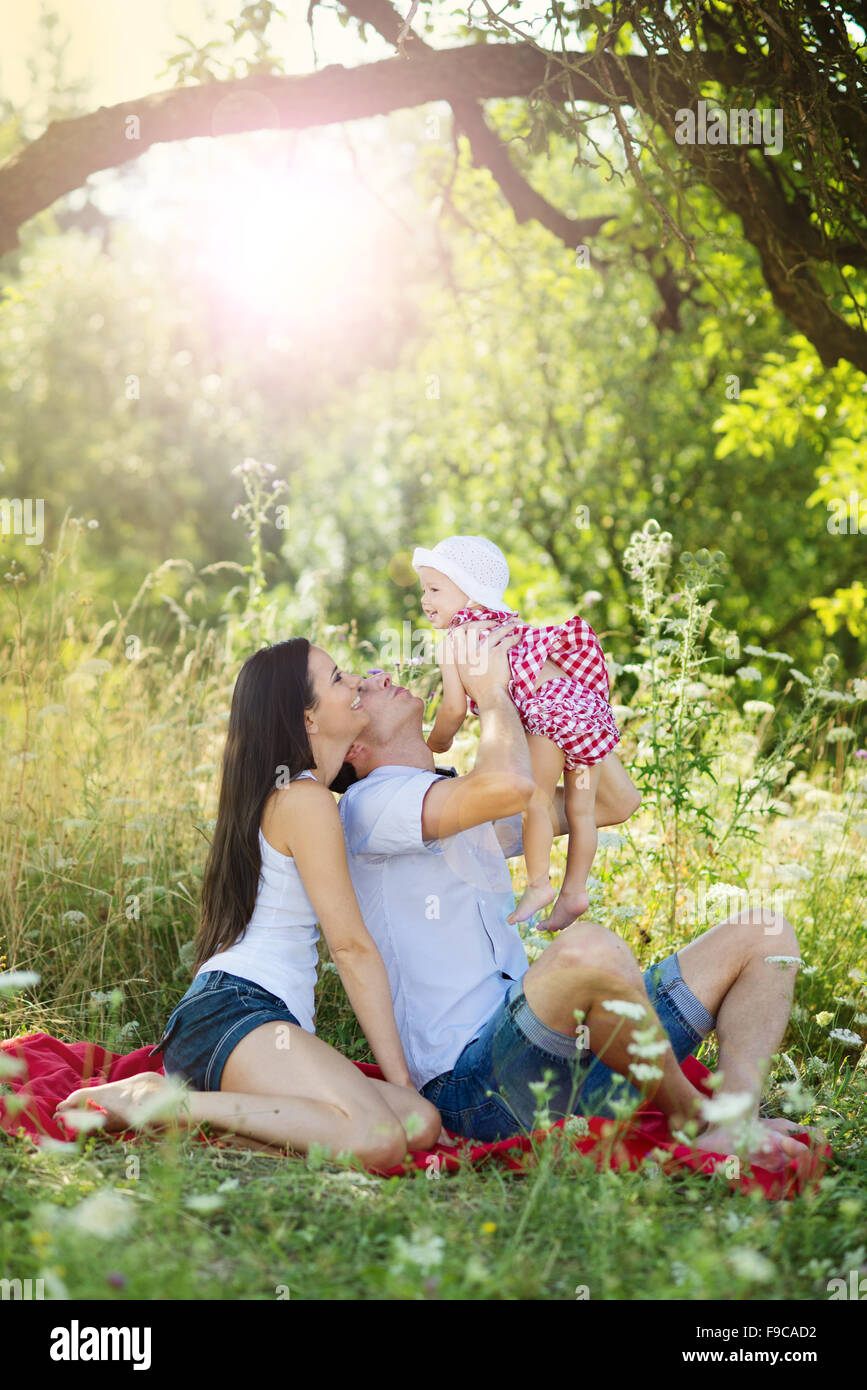 Happy young family spending time together in green nature. Stock Photo