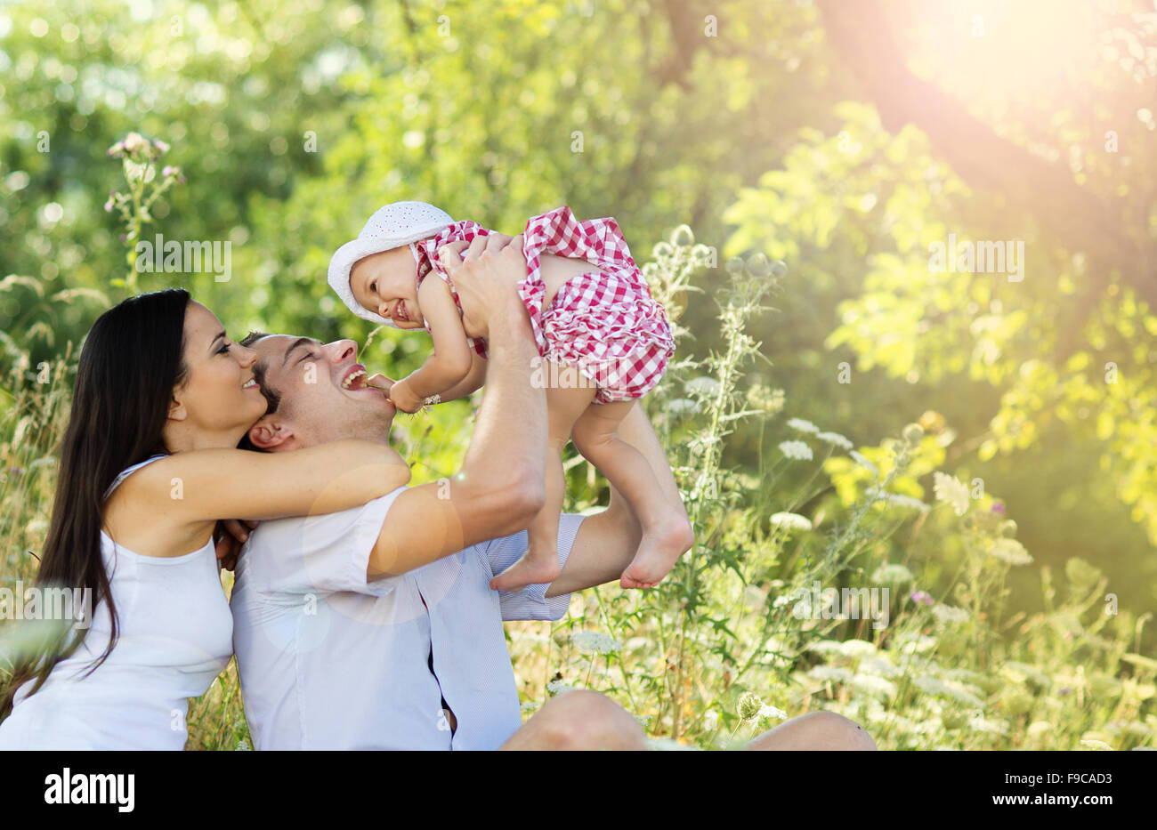 Happy young family spending time together in green nature. Stock Photo