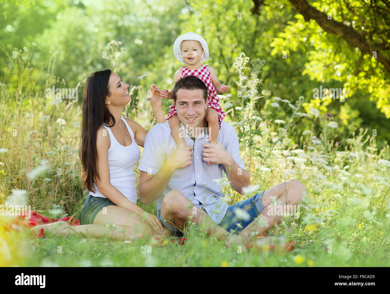 Happy young family spending time together in green nature. Stock Photo