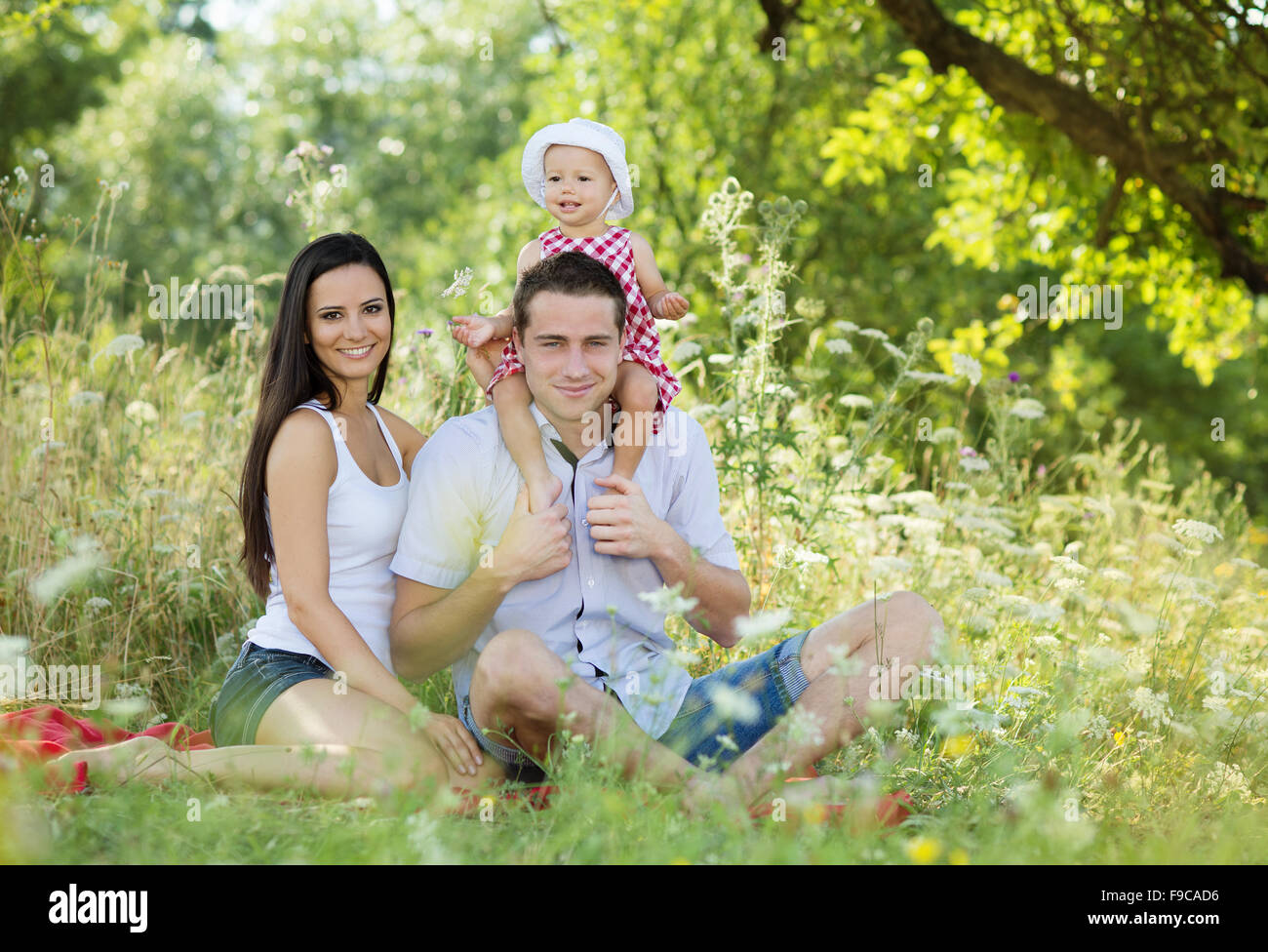 Happy young family spending time together in green nature. Stock Photo