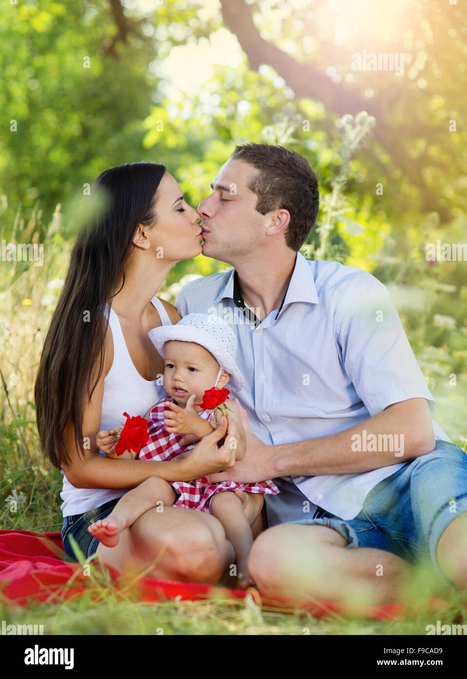 Happy young family spending time together in green nature. Stock Photo