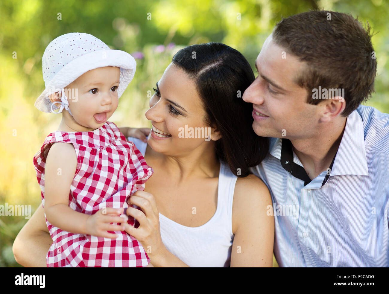 Happy young family spending time together in green nature. Stock Photo