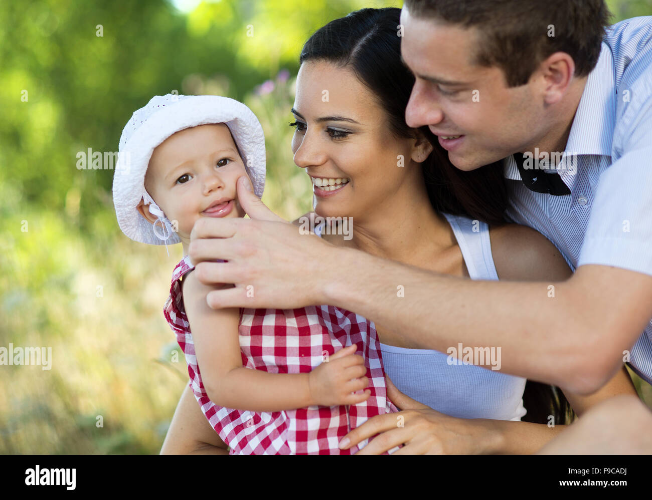 Happy young family spending time together in green nature. Stock Photo