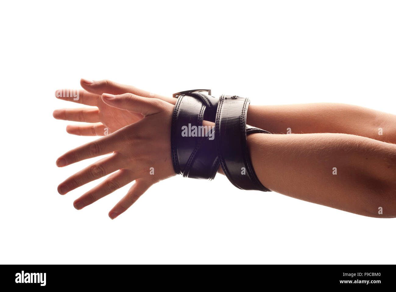 Hands of woman are tied up by belt. Stock Photo