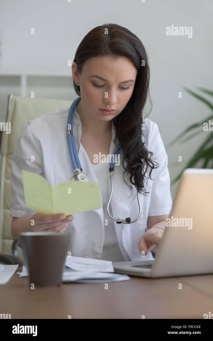 Doctor analyzing medical test results of her patient at her office Stock Photo