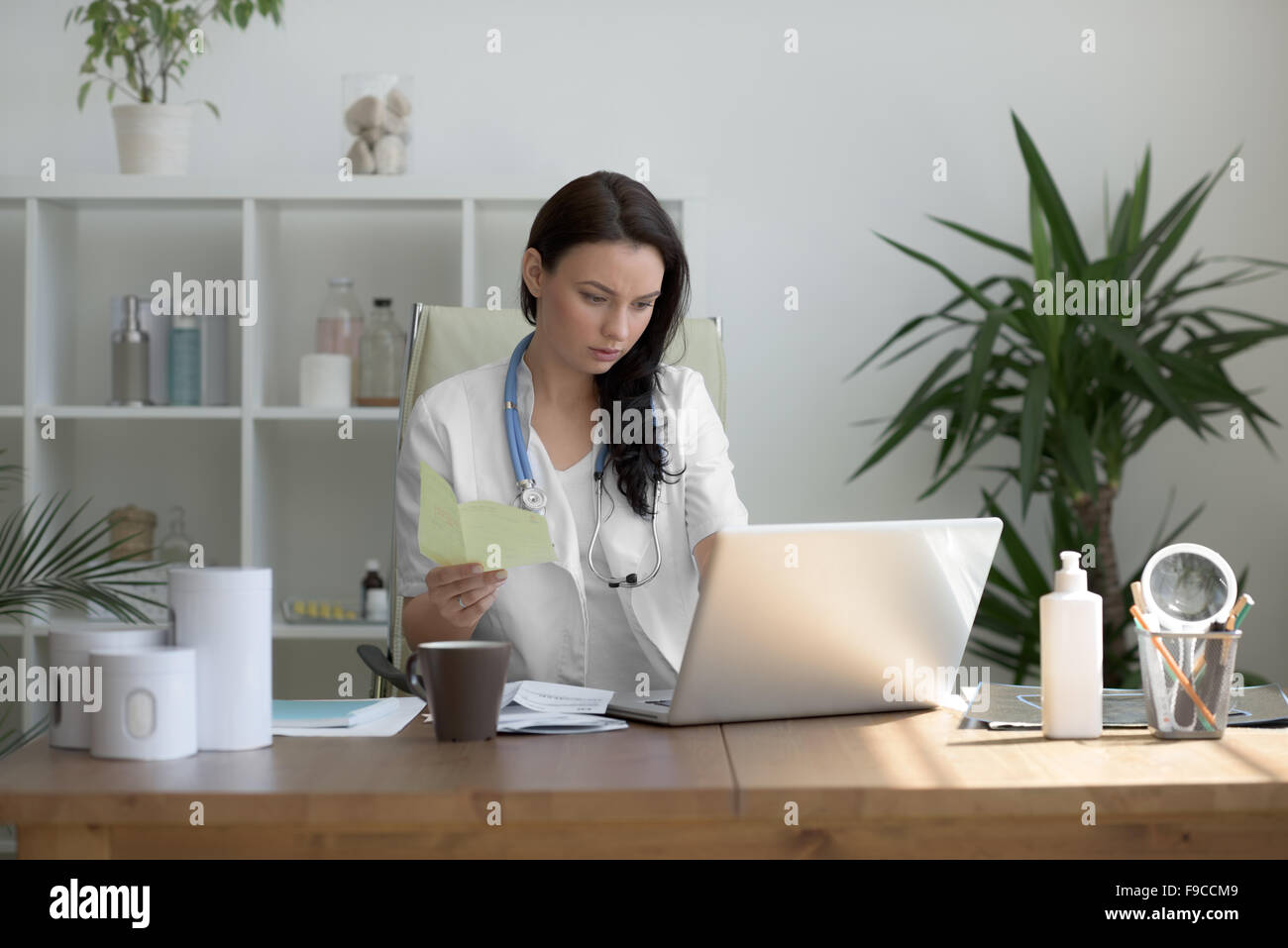 Doctor analyzing medical test results of her patient at her office Stock Photo