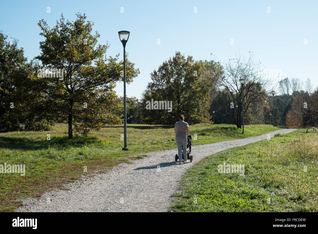 a mother walking with pram in park Stock Photo