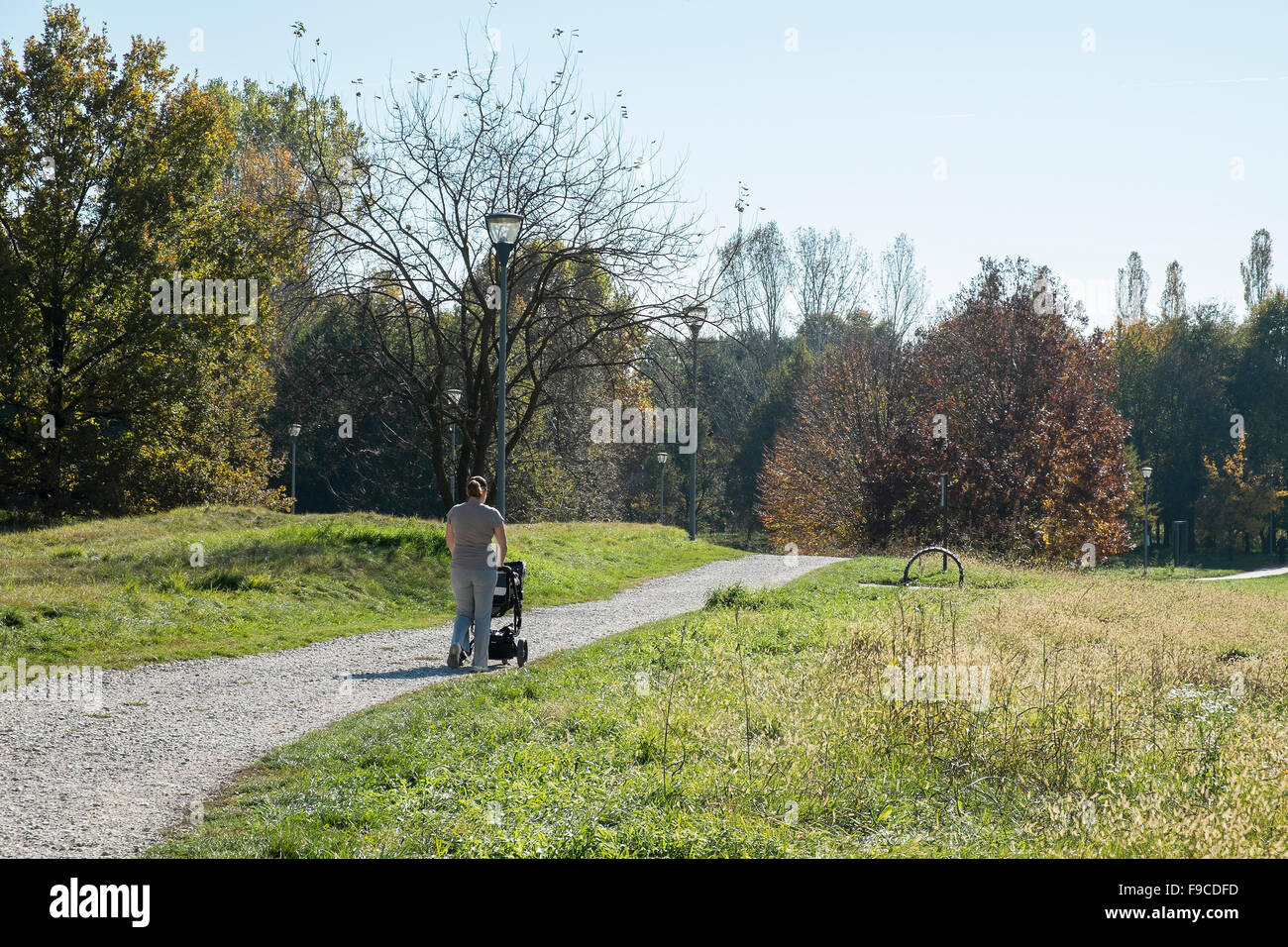 a mother walking with pram in park Stock Photo