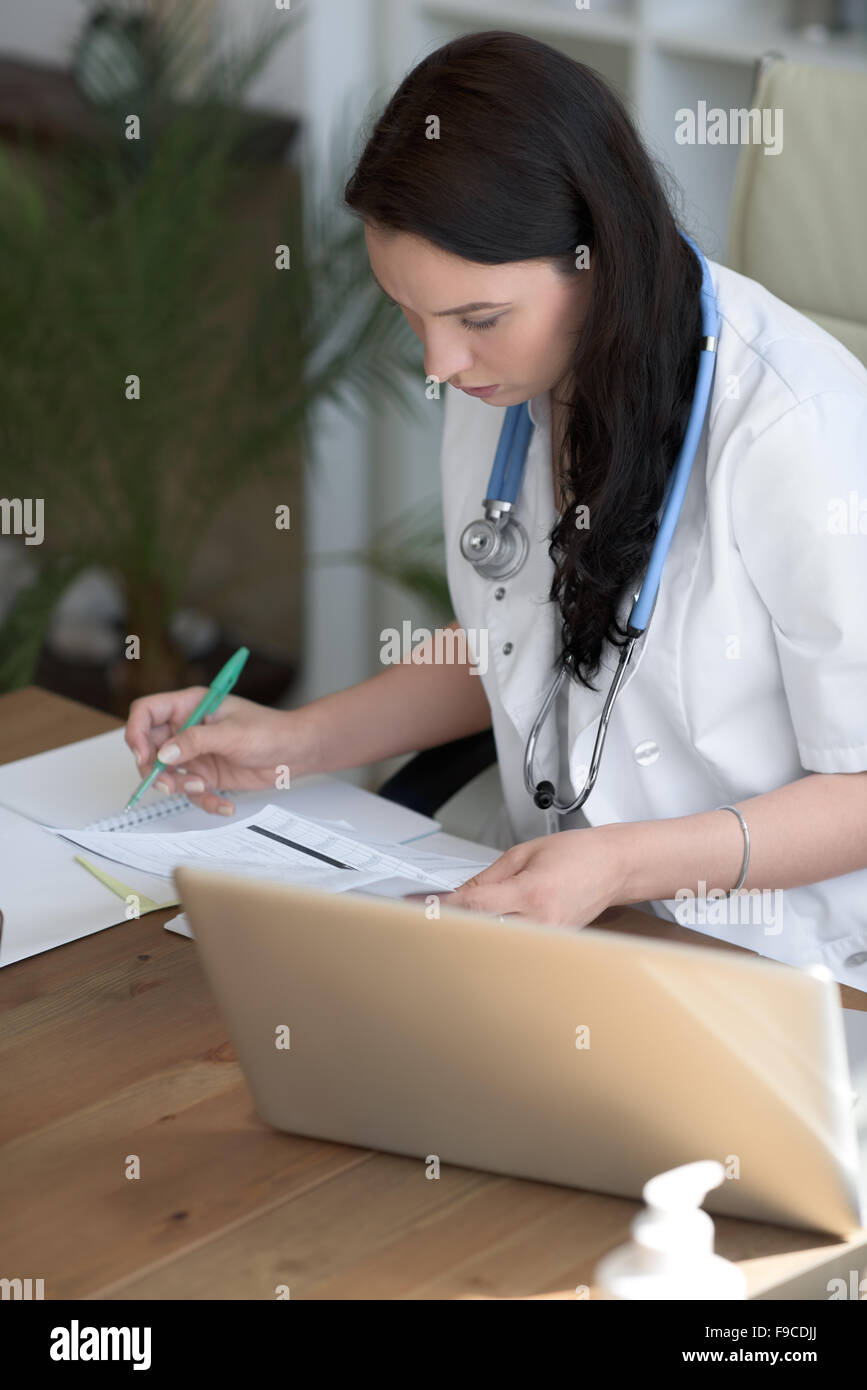 Doctor analyzing medical test results of her patient at her office Stock Photo