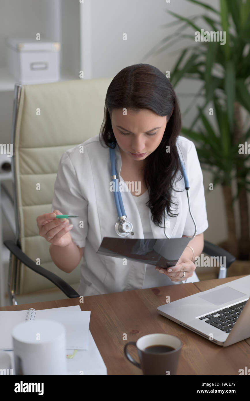 Medical doctor looking at xray of patient elbow at office Stock Photo