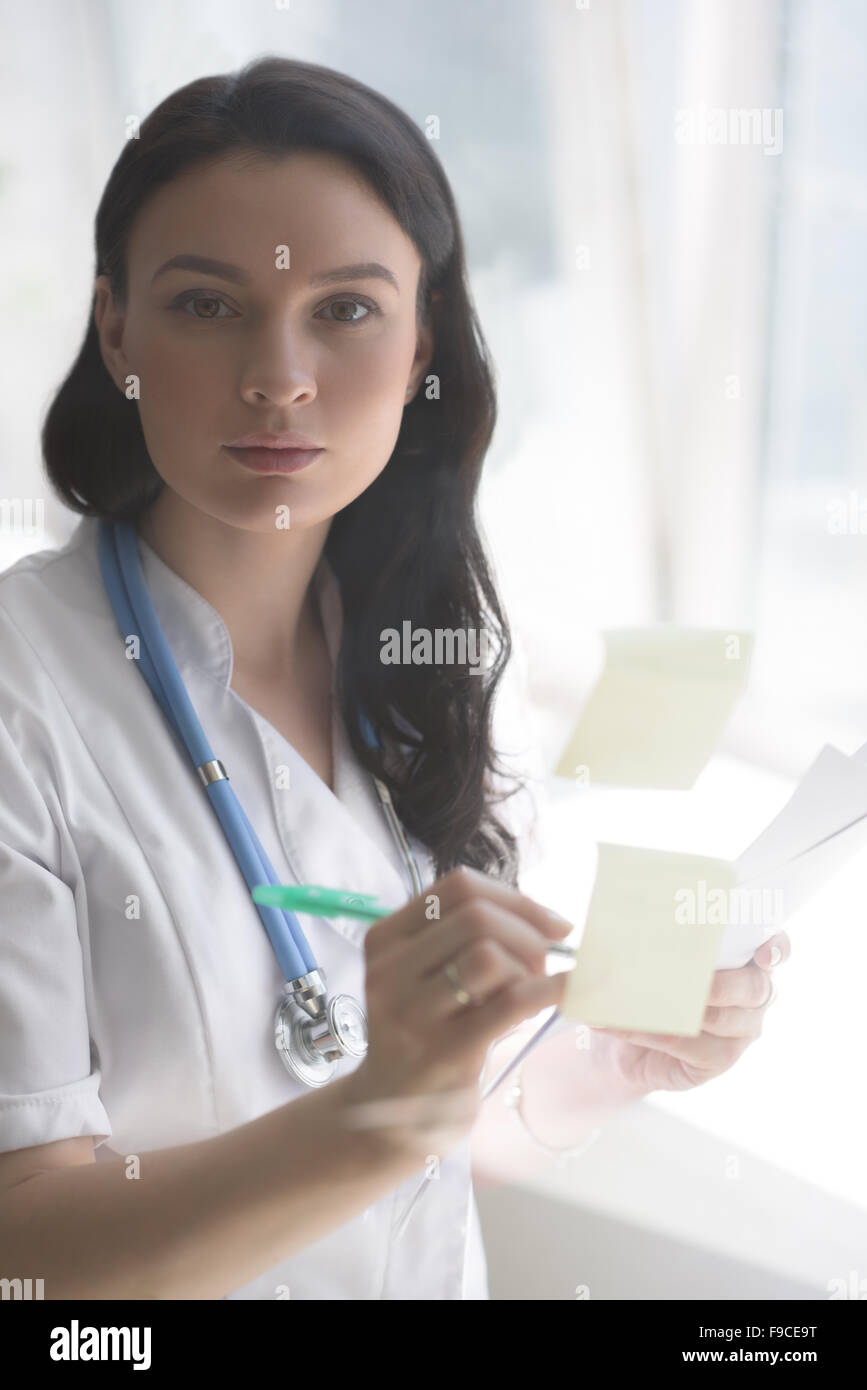 Medical doctor writing patient test results on transparent board to diagnose Stock Photo