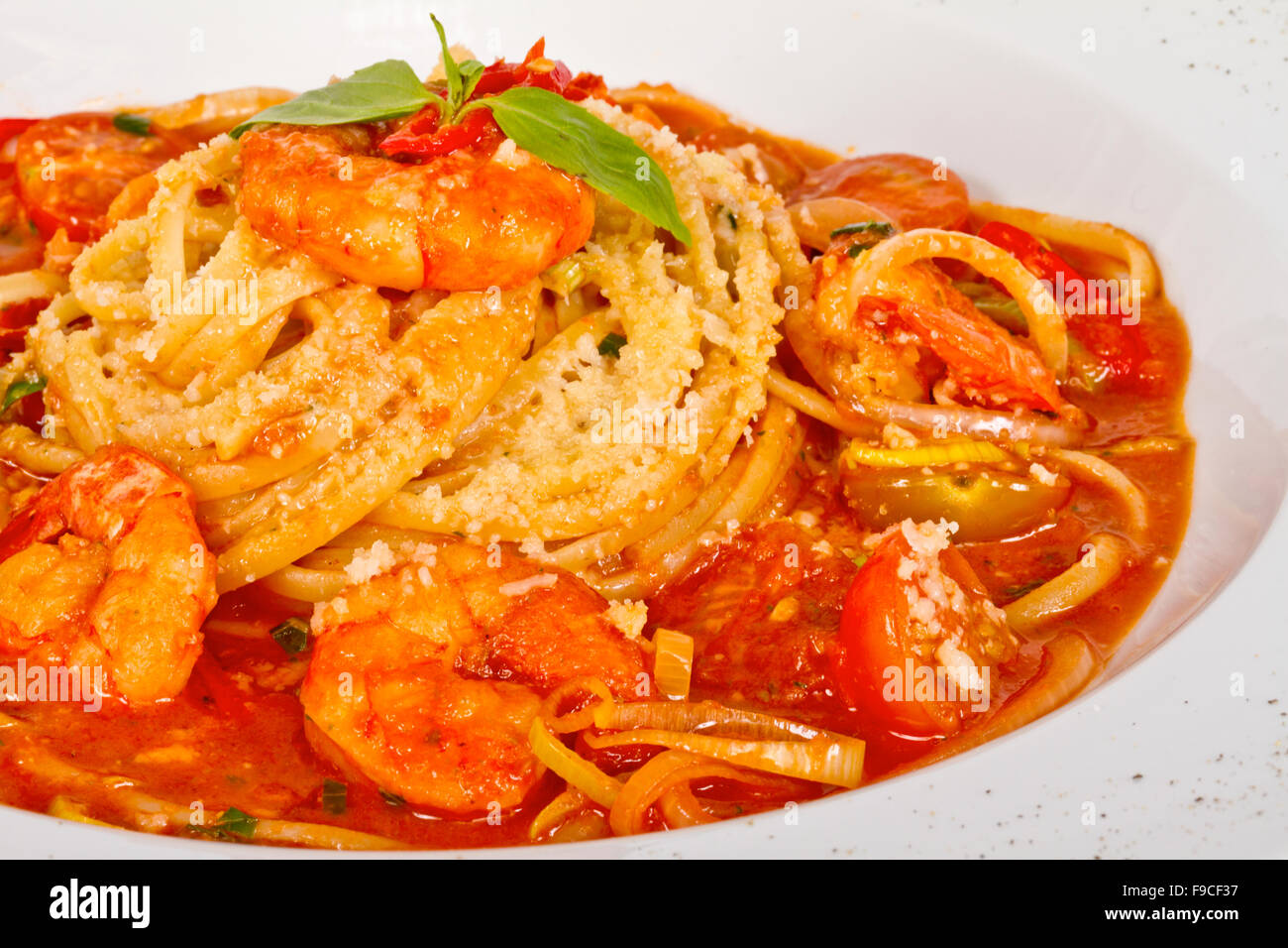 A plate of linguini with sauteed shrimp, tomato, chili and olive oil ...