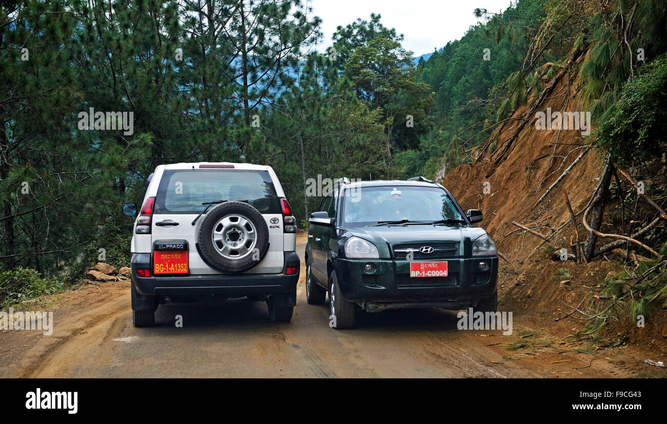 Two vehicles passing by each other narrowly on the Thimphu - Punakha Highway, Bhutan Stock Photo