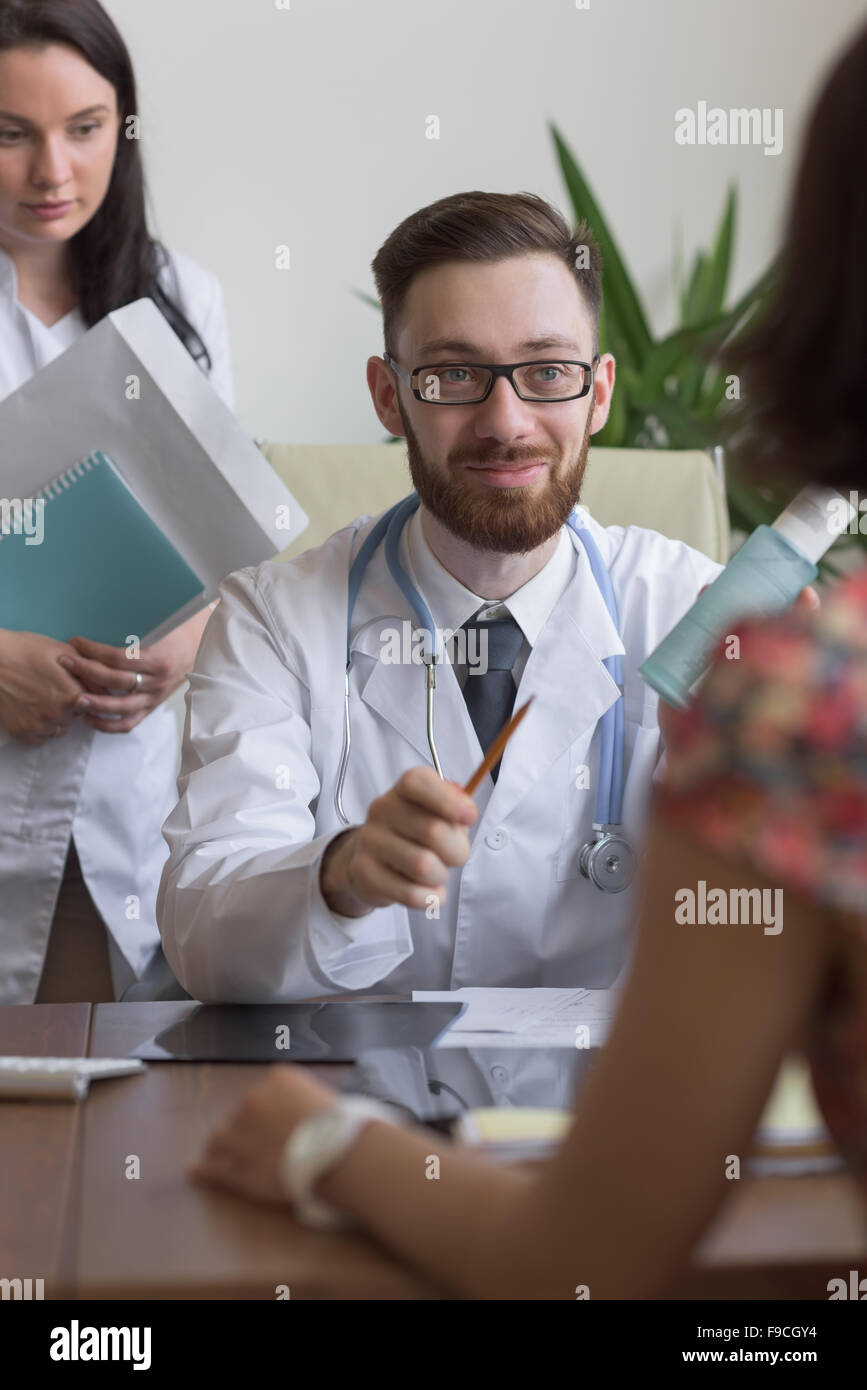 Confident practitioner consulting woman in hospital. Prescribing treatment Stock Photo