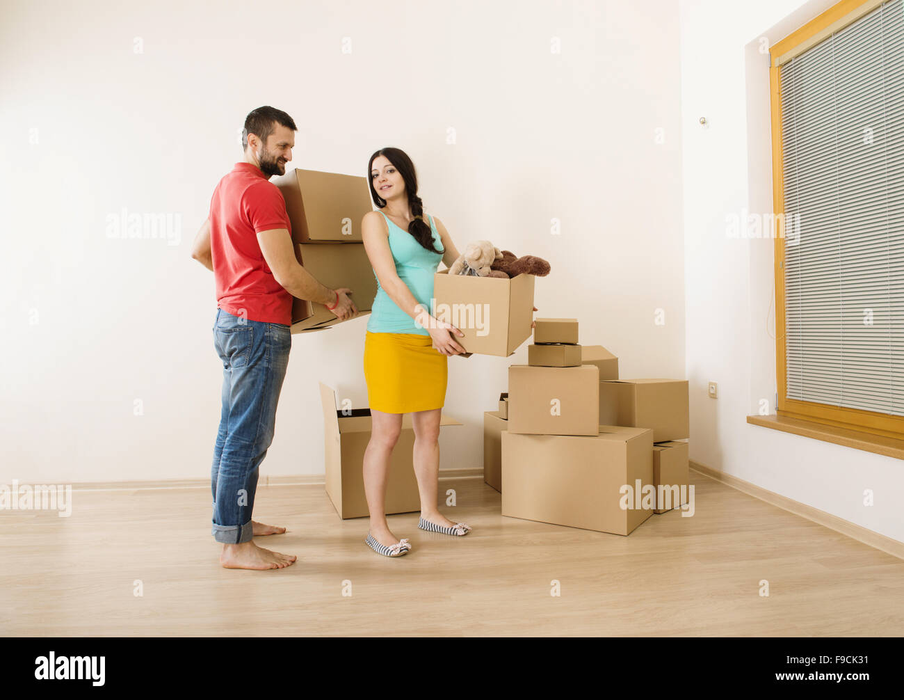 Young couple is moving into new house with lot of boxes. Woman is pregnant Stock Photo Alamy