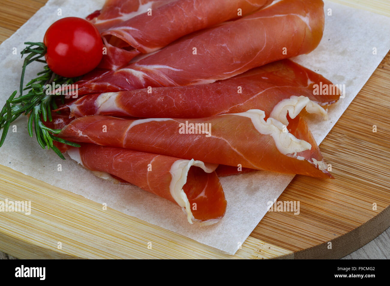 Spanish traditional snack Jamon with tomato and rosemary Stock Photo