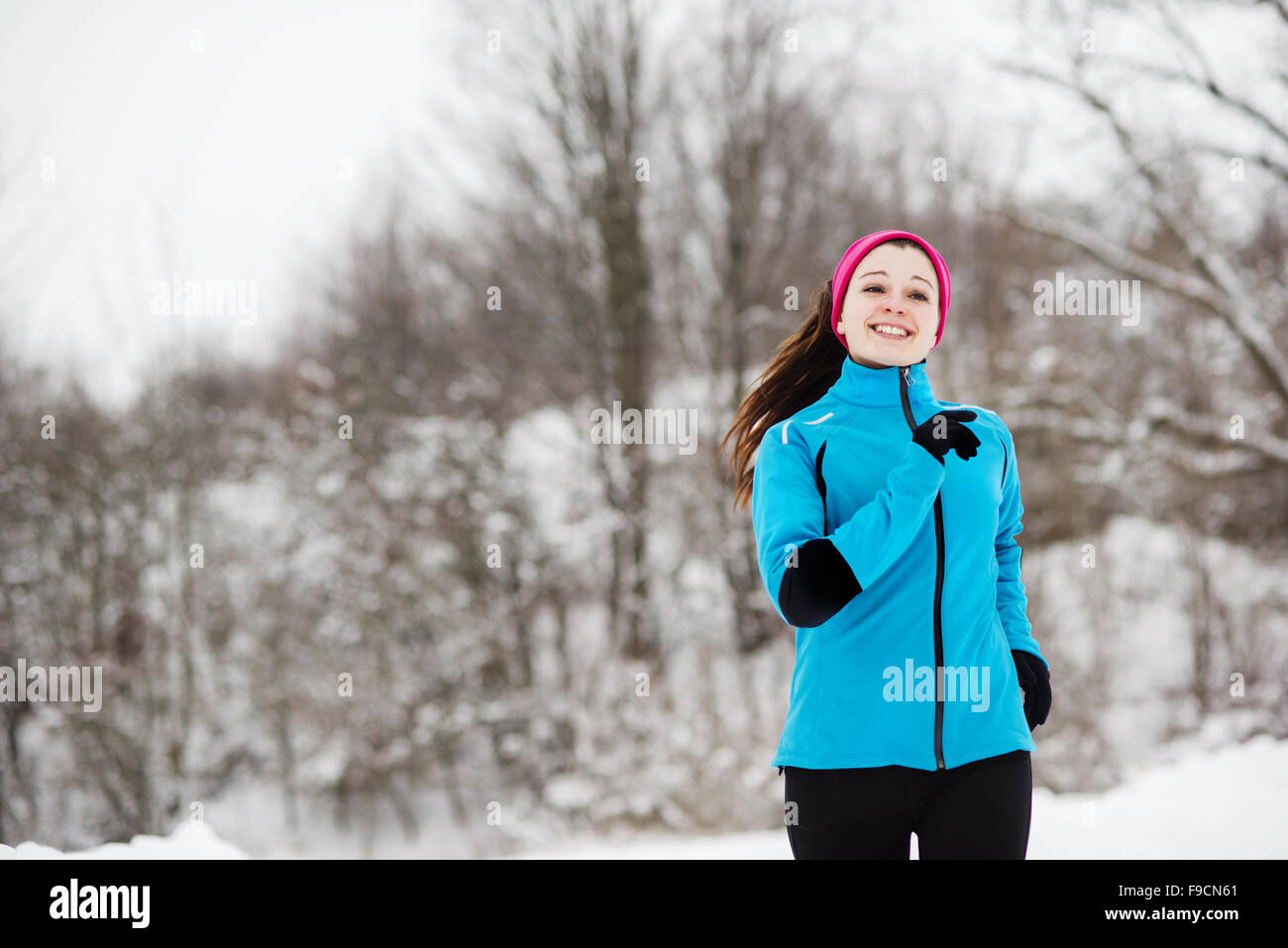 Athlete woman is running during winter training outside in cold snow weather. Stock Photo