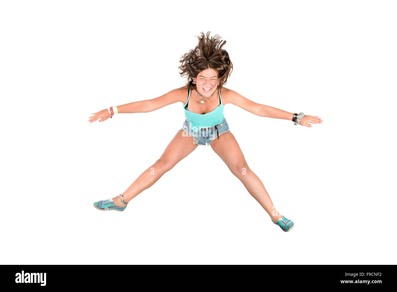 Young girl doing funny acrobatic jumps isolated in white Stock Photo