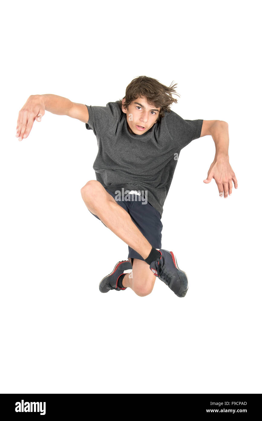 Teenage boy doing funny acrobatic jumps isolated in white Stock Photo