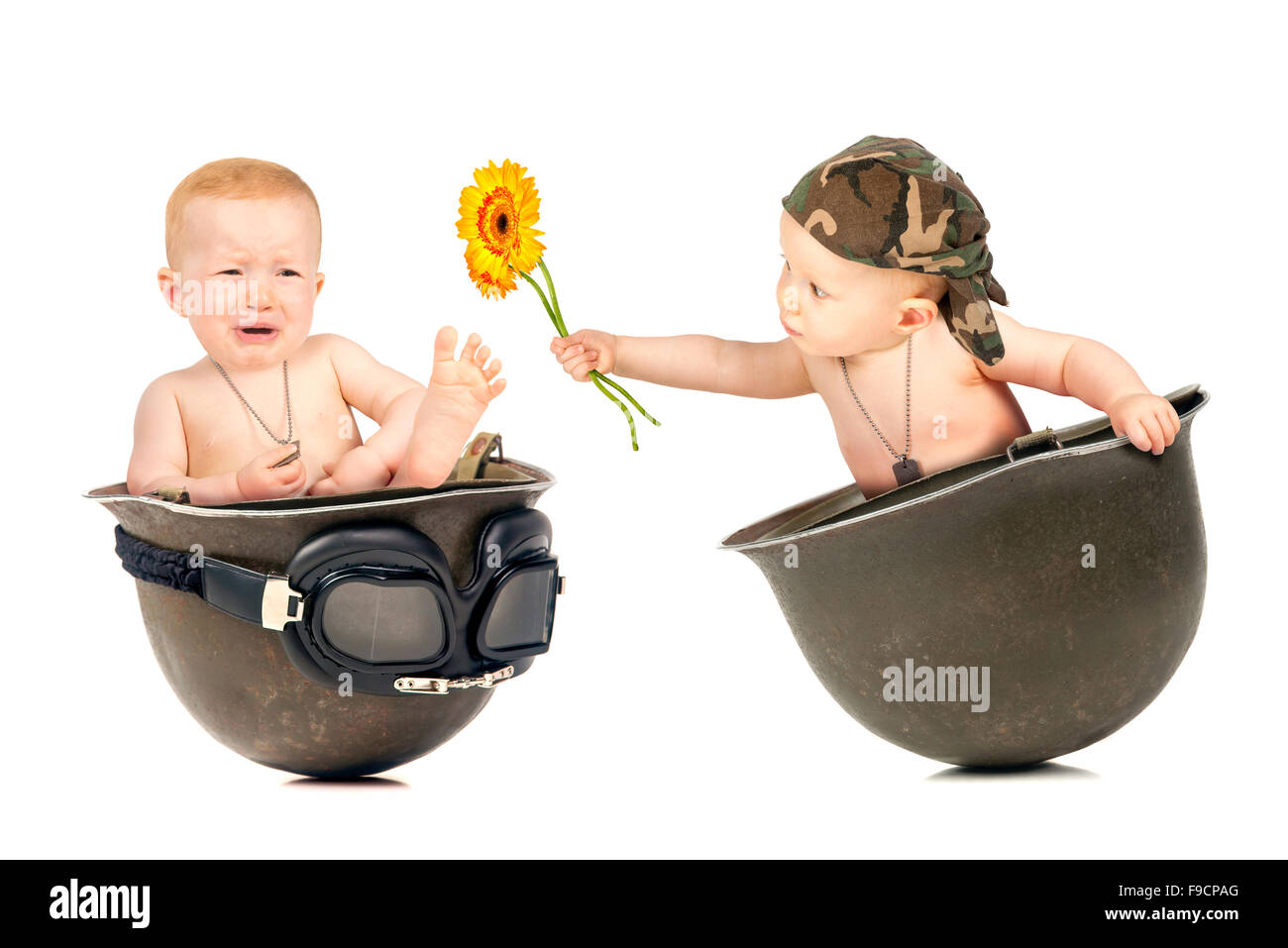 Cute baby girl duplicated inside an old military helmet Stock Photo